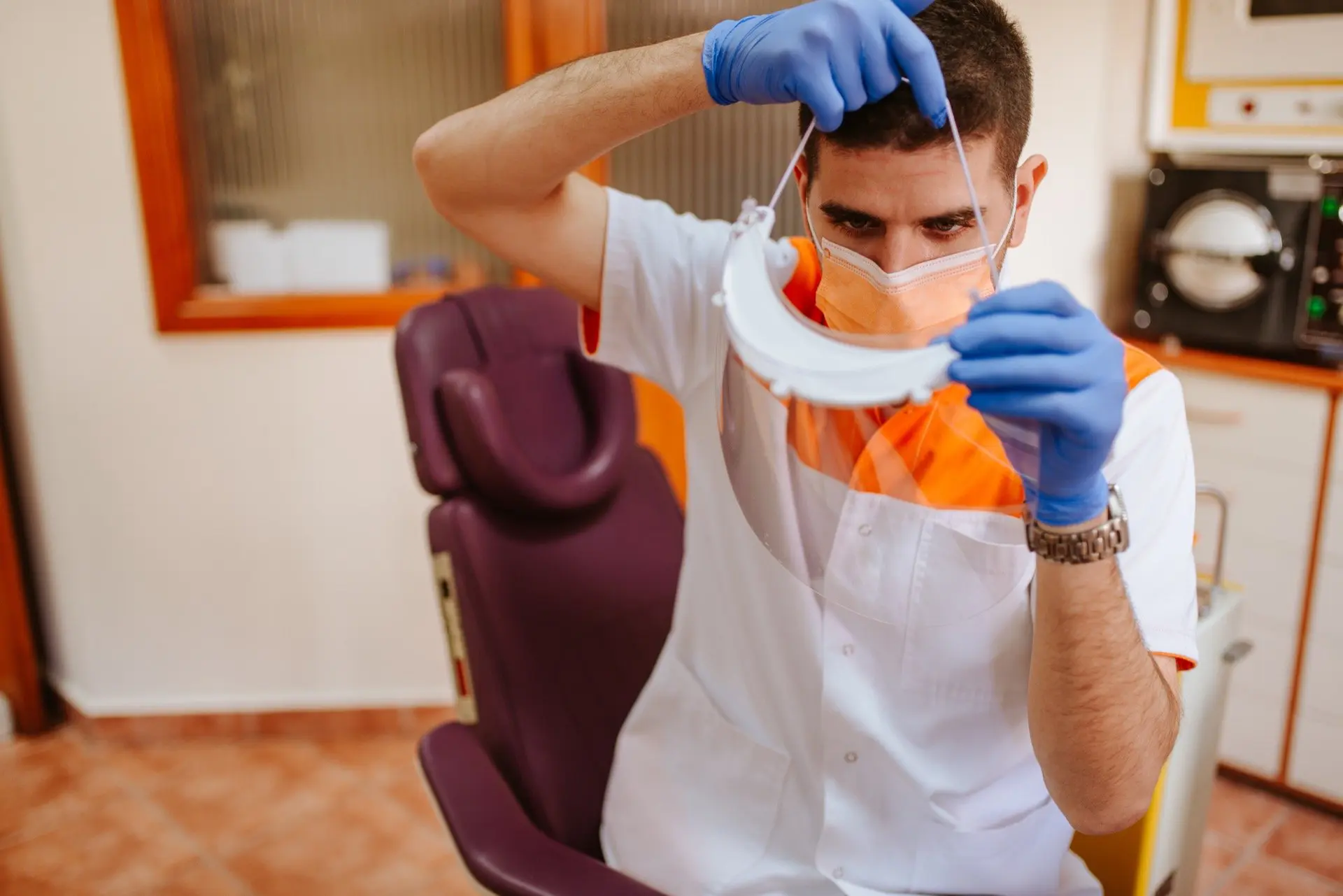 Kelowna dentist putting on face shield