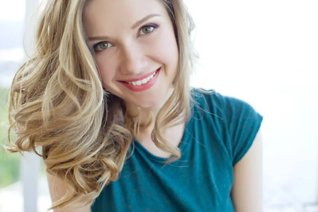 Young woman smiling after getting teeth whitening by dentist