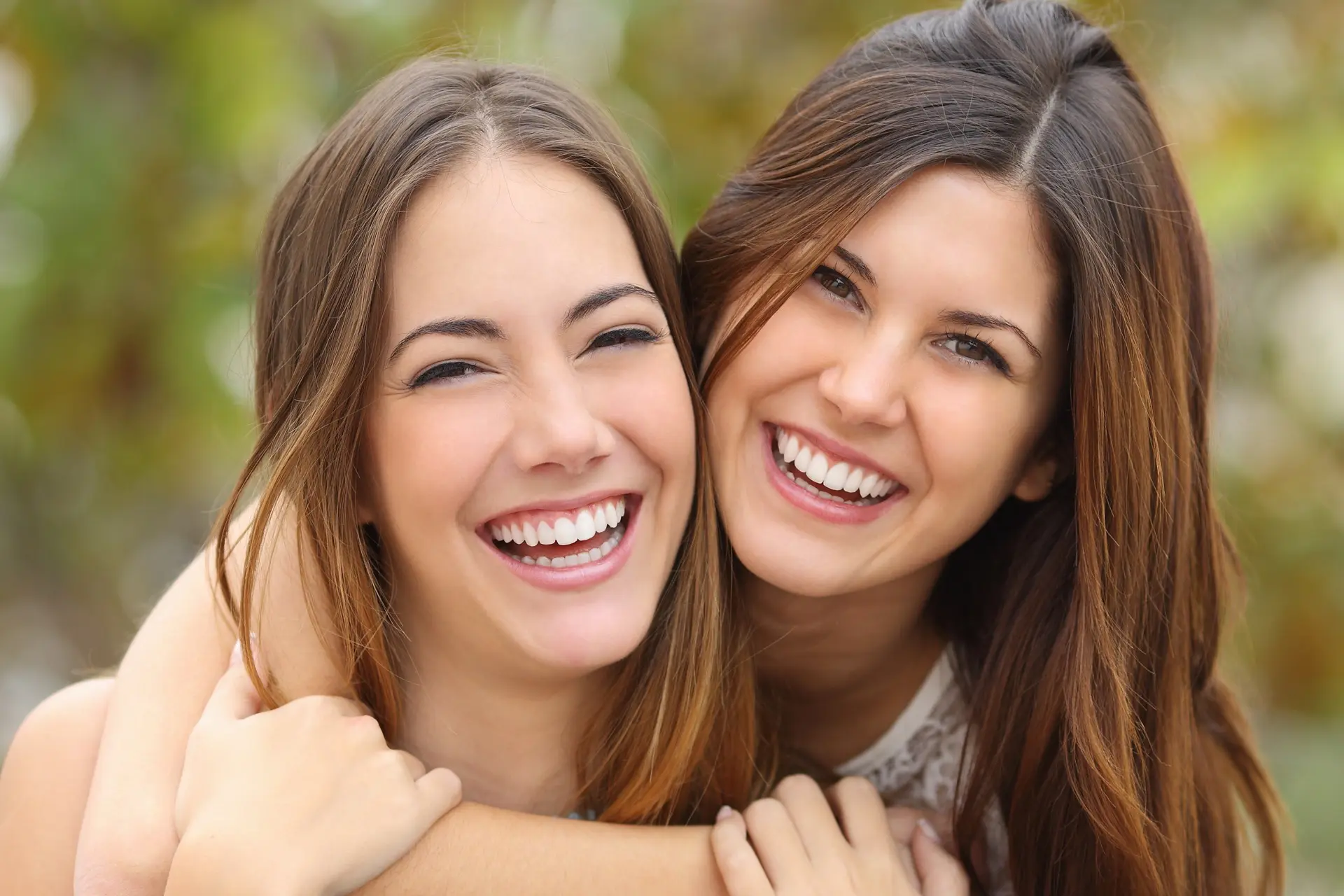 Two young women smiling after getting aesthetic dentistry done