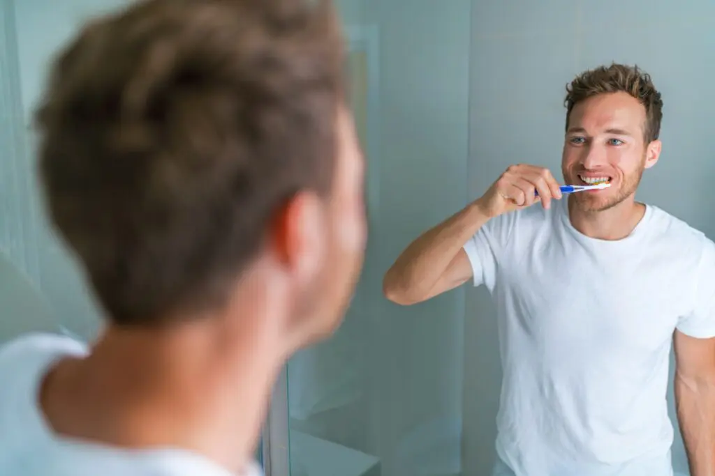 Man brushing sensitive teeth with soft toothbrush and sensitive toothpaste