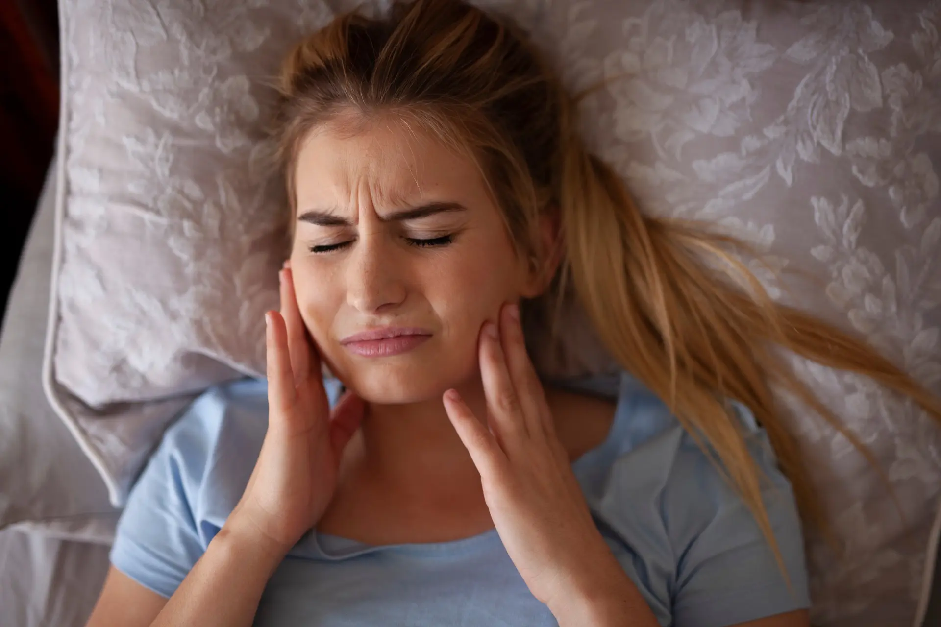 Woman experiencing Jaw pain who needs to see TMJ dentist in Kelowna