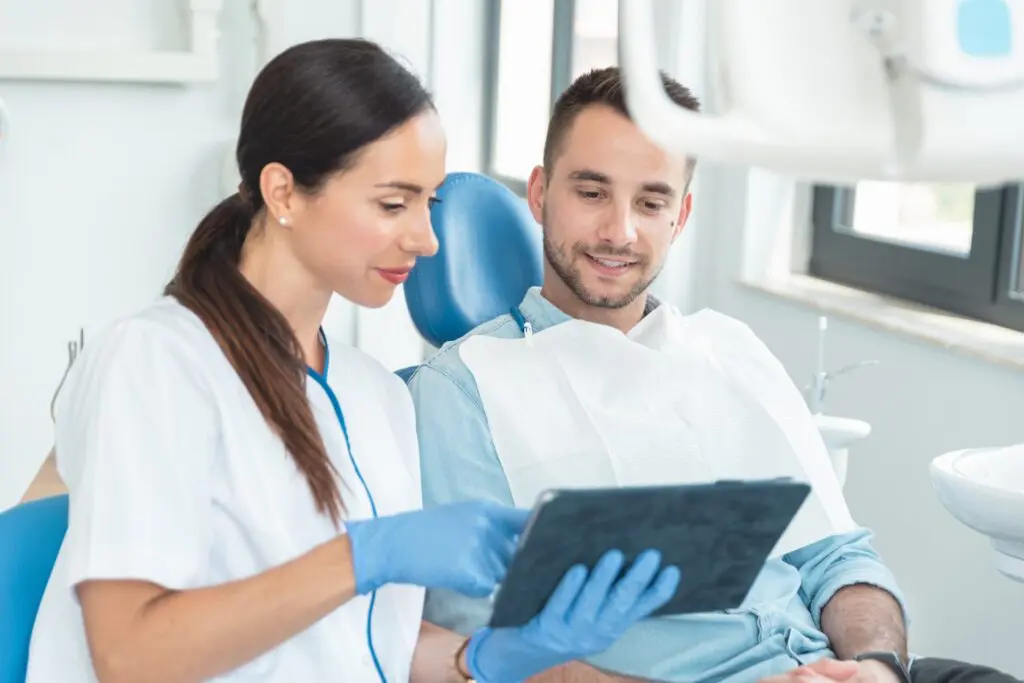 Dentist showing patient how she's going to treat tooth sensitivity