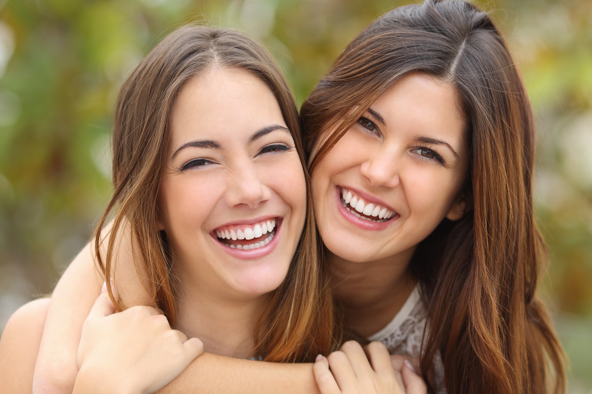 Two young women smiling after getting aesthetic dentistry done