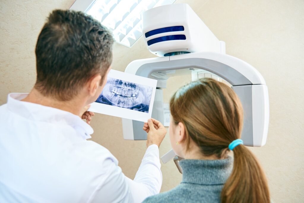 Dentist reviewing dental x-rays with patient