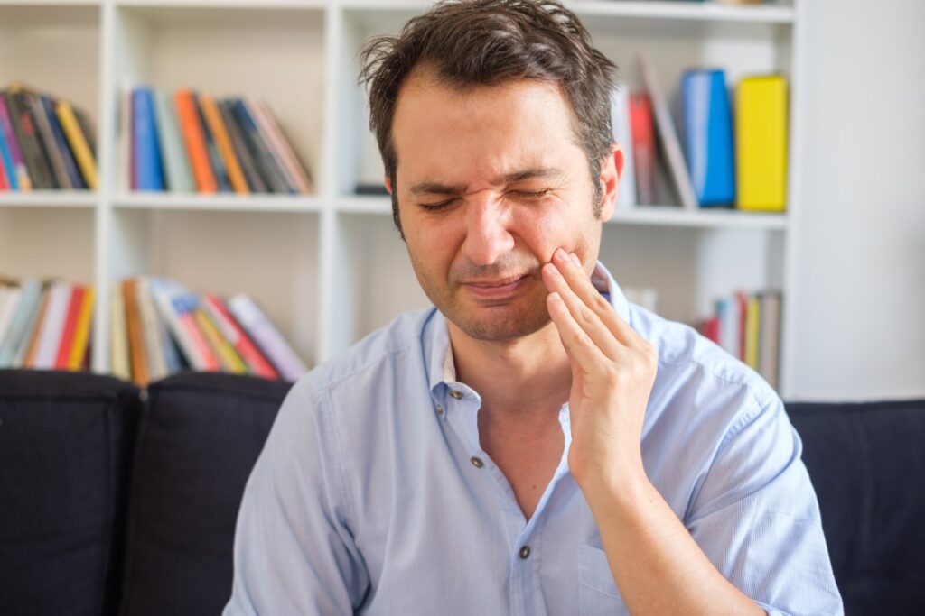 Man feeling toothache because of gum disease