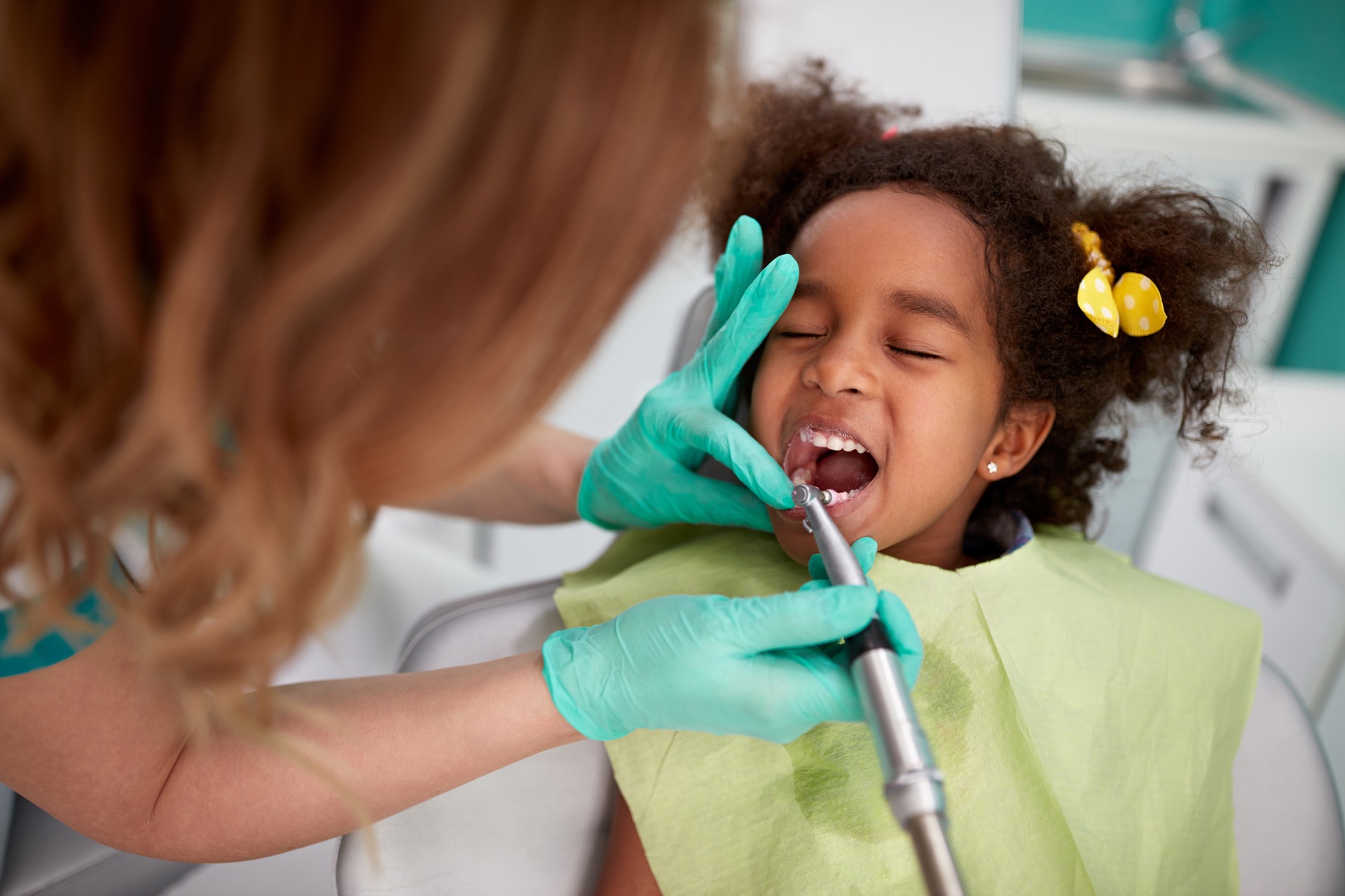 Dentist helping with dental hygiene for kids